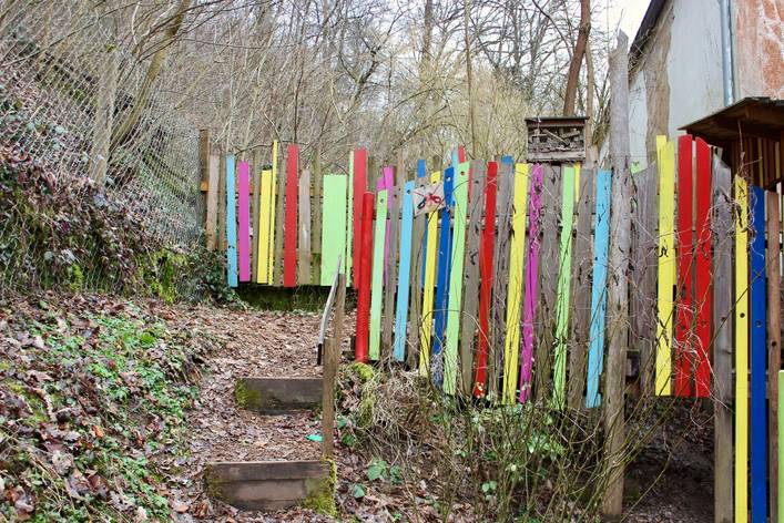 Außenbereich im Garten. Bunt bemalter Zaun.